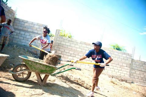 Image of student digging up the ground at a construction site