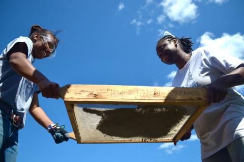 image of two Students sifting dirt for filtering purposes